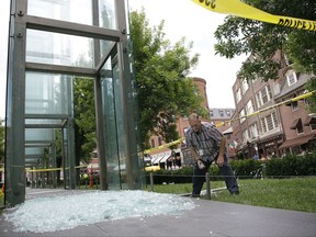 FILE- In this June 28, 2017, photo, Bill Satterlund, facilities manager for Combined Jewish Philanthropies of Boston, begins to pick-up broken glass from one of the Holocaust Memorial's glass panels shattered in Boston. The repaired Boston Holocaust memorial is being rededicated Tuesday, July 11, after it was vandalized last month. Authorities say James Isaac threw a rock through a glass panel at the memorial June 28. Isaac has pleaded not guilty to vandalism charges. (AP Photo/Stephan Savoia, File)