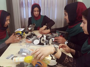 FILE- In this Thursday, July 6, 2017, file photo, teenagers from the Afghanistan Robotic House, a private training institute, practice at the Better Idea Organization center, in Herat, Afghanistan. U.S. President Donald Trump intervened to allow the group of Afghan girls into the country to participate in a robotics competition. White House spokeswoman Sarah Huckabee Sanders confirmed the president's intervention Wednesday, July 12, 2017. The six female students from Afghanistan had hoped to participate in an international robotics competition this month, but their visa applications to enter the U.S. were denied twice. (AP Photos/Ahmad Seir, File)