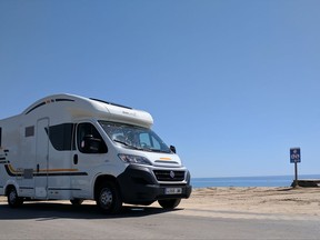 This June 14, 2017 photo shows a recreational vehicle parked by the beach in Alcossebre, Spain. Vacationing during Spain's touristy summer season doesn't have to mean overcrowded attractions and overpriced hotels and rental cars. Keep the crowds and fee hikes in the rearview mirror by renting a motorhome or RV (known more commonly as camper vans or caravans in Europe) and experience Spain's scenic Mediterranean coast through seaside towns, ancient ruins, bucolic orchards and sprawling badlands. (AP Photo/Nicole Evatt)