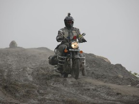 This September 2012 photo provided by Alisa Clickenger, shows Clickenger riding her motorcycle in India, descending the mountains headed for Manali. Clickenger operates Women's Motorcycle Tours, which conducts motorcycle rides that cater exclusively to women, and estimates she's traveled more than 250,000 miles on motorcycles. (Courtesy of Alisa Clickenger via AP)