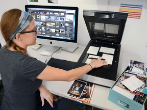 In this July 18, 2017 photo, imagining specialist Erin McClintic works in the lab at Phototronics in Winnetka, Ill., digitizing and archiving a shoebox of customer photographs, right. (Phototronics via AP)