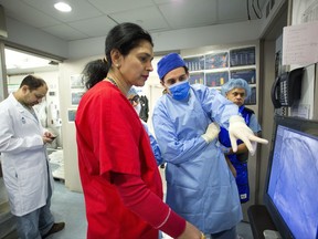 In this Feb. 16, 2017 photo, Dr. Annapoorna Kini, center, reviews a patient's angiogram before beginning a procedure, as a colleague points to the screen at Mount Sinai Hospital in New York. There's never been a better time to be treated for a heart attack. U.S. hospitals have set a record for how quickly they open blocked arteries, averaging under one hour for the first time since these results have been tracked, a new report finds. (AP Photo/Mark Lennihan)