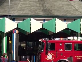 In this image made from a video by News12 Westchester (News12WC), firefighters extinguish a blaze in the carousel at the Playland amusement park in Rye, N.Y., Sunday afternoon, July 9, 2017. Images posted on Twitter by News12WC showed the fire under control about an hour after it broke out. It wasn't clear if the inside was damaged or if it was just the roof. (News12WC via AP)