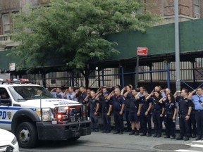 In this image taken from video, New York City Police and firefighters salute as the motorcade with the body of fallen NYPD officer Miosotis Familia leaves Bellevue Hospital in New York enroute to the funeral home, Thursday, July 6, 2017, in New York. Familia was shot and killed while on duty in the early hours of July 6 as she wrote in her notebook inside an NYPD Mobile Command Vehicle. (AP Photo/Robert Weisenfeld)