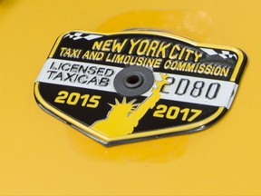 In this June 26, 2017 photo, the medallion of taxi driver and taxi medallion owner Marcelino Hervias is affixed to the hood of his taxicab on New York's Upper West Side. Three credit unions that specialized in loaning money against cab medallions, the hard-to-get licenses that allow traditional taxis to operate, have been placed into conservatorship as the value of those medallions has plummeted. (AP Photo/Richard Drew)