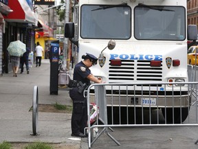 A police officer works near the site where an officer was killed in the Bronx section of New York, Thursday, July 6, 2017.  Police officer Miosotis Familia was shot to death early Wednesday, ambushed inside her command post by an ex-convict, authorities said. He was later killed after pulling a gun on police. (AP Photo/Seth Wenig)