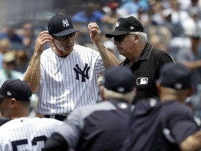 New York Yankees' Joe Girardi, left, talks to first base umpire Larry Vanover after Milwaukee Brewers' Travis Shaw was hit by a pitch from Yankees starting pitcher Luis Severino during the first inning of an interleague baseball game, Saturday, July 8, 2017, at Yankee Stadium in New York. (AP Photo/Julio Cortez)