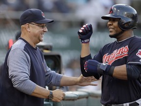 Cleveland Indians' Edwin Encarnacion, right, is congratulated by manager Terry Francona after scoring against the Oakland Athletics in the sixth inning of a baseball game Saturday, July 15, 2017, in Oakland, Calif. Encarnacion scored on a ground-out by Indians' Carlos Santana. (AP Photo/Ben Margot)