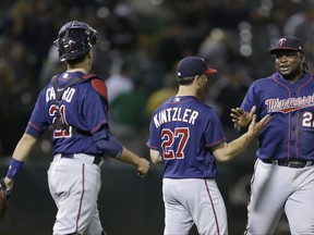 Minnesota Twins pitcher Brandon Kintzler (27) celebrates the team's 6-3 win over the Oakland Athletics with catcher Jason Castro, left, and Miguel Sano (22), following a baseball game Friday, July 28, 2017, in Oakland, Calif. (AP Photo/Ben Margot)