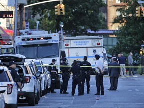 Emergency personnel stand near the scene where a police officer was fatally shot while sitting in a marked vehicle in the Bronx section of New York, Wednesday, July 5, 2017. Police said Officer Miosotis Familia died at a hospital early Wednesday.