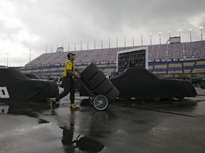 Crews begin to load up their pit area as the track is dried during a rain delay before the NASCAR Trucks auto race at Kentucky Speedway in Sparta, Ky., Thursday, July 6, 2017. (Sam Greene/The Cincinnati Enquirer via AP)