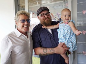 Roger Daltrey, lead singer for the English rock band The Who, left, poses with Adam Kirk and his daughter Sawyer McGhee, a cancer patient, in Cleveland, Ohio, on Monday, July 24, 2017.  (AP photo/Dake Kang)