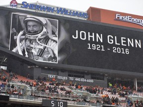 FILE – In this Dec. 11, 2016, file photo, a screen shows a photo commemorating astronaut and U.S. Sen. John Glenn before an NFL football game between the Cincinnati Bengals and the Cleveland Browns in Cleveland. Glenn's devotees are pushing forward with ideas for memorials and honors as the anniversary of the astronaut's birth arrives Tuesday, July 18, 2017, for the first time since his death on Dec. 8, 2016, at age 95. (AP Photo/David Richard, File)