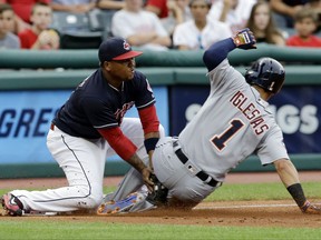 Detroit Tigers' Jose Iglesias, right, is tagged out at third base by Cleveland Indians' Jose Ramirez during the third inning of a baseball game, Friday, July 7, 2017, in Cleveland. (AP Photo/Tony Dejak)