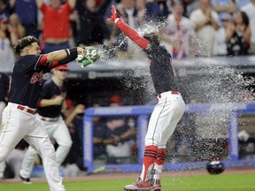 Cleveland Indians' Giovanny Urshela, left, douses teammate Francisco Lindor after Lindor hit a solo home run in the 10th inning of a baseball game against the Toronto Blue Jays, Saturday, July 22, 2017, in Cleveland. (AP Photo/Tony Dejak)