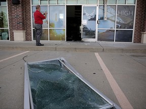 Indrek Redard, who works for the property management company, views damage Tuesday, July 11, 2017, after an explosion Monday night outside an Air Force recruitment office in Bixby, Okla. The center was closed at the time and no one was injured. The explosion is being investigated as a possible act of domestic terrorism, but the late-night blast could also have been a horrible prank, a federal agent said Tuesday.  (Mike Simons//Tulsa World via AP)