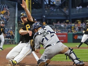 Pittsburgh Pirates' Chad Kuhl, left, collides with Milwaukee Brewers catcher Stephen Vogt while being tagged out during the fifth inning of a baseball game in Pittsburgh, Monday, July 17, 2017. Both players were shaken up on the play and Vogt left the game. (AP Photo/Gene J. Puskar)