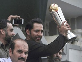 FILE - In this June 20, 2017 file photo, Pakistani cricket team's skipper Sarfraz Ahmed raises Champions Trophy for a crowd gathered to welcome him, outside his residence in Karachi, Pakistan. The Pakistan Cricket Board on Tuesday, July 4, 2017, appointed Ahmed as test captain after the wicketkeeper-batsman successfully led the team to win Champions Trophy in England last month. (AP Photo/Fareed Khan, File)