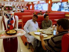 A robot waitress serves food to customers at a pizza restaurant in Multan, Pakistan, Thursday, July 6, 2017. A Pakistani engineer says sale of Pizza at his father's shop has doubled in recent months after he introduced first ever robot to serve food to customers in the central city of Multan. (AP Photo/Iram Asim)