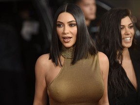 FILE - In this April 12, 2017, file photo, Kim Kardashian West, left, and Kourtney Kardashian arrive at the U.S. premiere of "The Promise" at the TCL Chinese Theatre in Los Angeles. West explained Tuesday, July 11, 2017, that the pair of white streaks spotted on a black table from a social media post created at a hotel she's staying at were just part of the table's marble stone.(Photo by Chris Pizzello/Invision/AP, File)