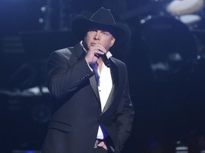 FILE - In this Nov. 2, 2016 file photo, Garth Brooks performs at the 50th annual CMA Awards in Nashville, Tenn. Brooks offered to pay for a Hawaiian honeymoon for a couple that got engaged at his Oklahoma City concert on July 15, 2017. (Photo by Charles Sykes/Invision/AP, File)