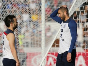 FILE - In this June 10, 2014 file photo, France's Mathieu Valbuena, left, and Karim Benzema, right, chat during a training session of the french national soccer team, at the Santa Cruz Stadium in Ribeirao Preto, Brazil. France's highest court has ruled Tuesday July 11, 2017 in favor of Real Madrid forward Benzema in a blackmail case linked to a sex tape involving his France teammate Valbuena, saying the investigation against the French striker was unfair. (AP Photo/David Vincent, File)
