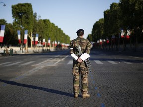A French soldier waits on the Champs Elysees avenue before Bastille Day parade in Paris, Friday, July 14, 2017. U.S President Donald Trump and First Lady Melania Trump will attend Bastille Day celebrations. (AP Photo/Kamil Zihnioglu)