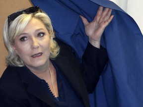 FILE - In this June 18, 2017 file photo, French far-right presidential candidate, Marine Le Pen exits a voting booth in Henin Beaumont, Northern France. Marine Le Pen far-right National Front party is holding a high-tension meeting Friday July 21, 2017, that could lead to a name change and a rethink of its demand to pull France out of the euro. (AP Photo/Michel Spingler, File)