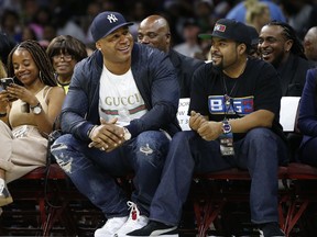 LL Cool J, second from front left, and Ice Cube watch the action as The Power plays the Ghost Ballers during the first half of Game 1 in the BIG3 Basketball League in Philadelphia, Pa., Sunday, July 16, 2017. (AP Photo/Rich Schultz)