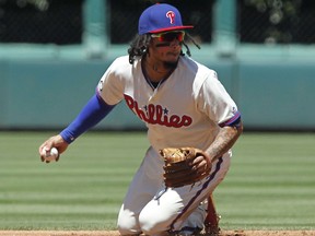 Philadelphia Phillies' Fredy Galvis looks toward second base before completing a double play during the second inning of a baseball game against the Atlanta Braves, Sunday, July 30, 2017, in Philadelphia. (AP Photo/Tom Mihalek)