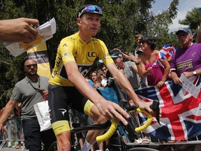 Britain's Chris Froome, wearing the overall leader's yellow jersey, passes the Union Jack as he arrives for the start of the nineteenth stage of the Tour de France cycling race over 222.5 kilometers (138.3 miles) with start in Embrun and finish in Salon-de-Provence, France, Friday, July 21, 2017. (AP Photo/Christophe Ena)