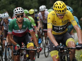 Britain's Chris Froome, wearing the overall leader's yellow jersey, and Italy's Fabio Aru climb during the seventeenth stage of the Tour de France cycling race over 183 kilometers (113.7 miles) with start in La Mure and finish in Serre-Chevalier, France, Wednesday, July 19, 2017. (AP Photo/Christophe Ena)