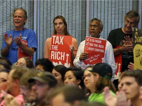 Audience members applaud as they look on during public comments at a Seattle City Council meeting where a new city income tax on the wealthy was being considered Monday, July 10, 2017, in Seattle.