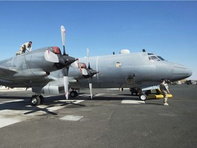 Members of the Canadian Forces work on a CP140 Aurora surveillance plane at the Canadian Forces base in the Persian Gulf, Sunday, February 19, 2017.