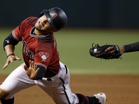Arizona Diamondbacks' Gregor Blanco eludes the tag attempt by Atlanta Braves' Johan Camargo as Blanco dives for third base during the first inning of a baseball game Wednesday, July 26, 2017, in Phoenix. The Diamondbacks' Blanco was awarded a stolen base on the play. (AP Photo/Ross D. Franklin)