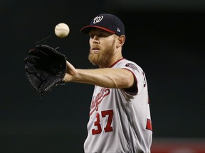 Washington Nationals' Stephen Strasburg gets the baseball back from his catcher as he warms up during the first inning of a baseball game against the Arizona Diamondbacks, Sunday, July 23, 2017, in Phoenix. (AP Photo/Ross D. Franklin)
