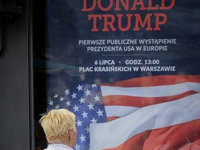 In this photo taken on Saturday, July 1, 2017, a woman stops to read a poster advertising U.S. President Donald Trump's speech, that reads "Donald Trump. First Public Appearance in Europe", in Warsaw, Poland. President Donald Trump is breaking tradition by visiting Poland, an ex-communist country in central Europe, before making a presidential visit to longtime allies Britain, France and Germany. The White House has stressed Poland's importance as a loyal NATO ally and its potential as an energy partner as reasons for the visit, which he will make Thursday, July 6. (AP Photo/Alik Keplicz)