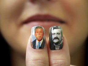 FILE - In this Thursday, March 31, 2005, file photo a woman in Czestochowa, Poland, shows her thumbnails decorated with portraits of Poland's Solidarity leader Lech Walesa, right, and U.S. President George W. Bush. When President Donald Trump arrives in Warsaw, on Wednesday, July 5, 2017, with his wife Melania, he will be the eight U.S. president to visit Poland, a Central European nation that peacefully shed Moscow's dominance in 1989, joined NATO in 1999 and the European Union in 2004, and which is one of the staunchest U.S. allies in Europe. (AP Photo/Jacek Sroda, File)