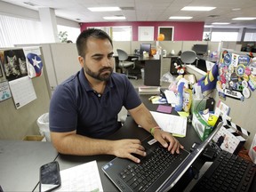 In this Monday, June 26, 2017 photo, Ricardo Negron works at his office in Orlando, Fla., where he runs a community center. Negron, who trained as a lawyer in Puerto Rico, said he doesn't have the time or the money to take off three months to study for the Florida bar exam to practice law. (AP Photo/John Raoux)