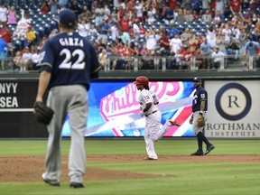Philadelphia Phillies' Freddy Galvis, center, rounds the bases past Milwaukee Brewers' Jonathan Villar, right, after hitting a tw- run home run off Matt Garza (22) during the first inning of a baseball game, Friday, July 21, 2017, in Philadelphia. (AP Photo/Derik Hamilton)