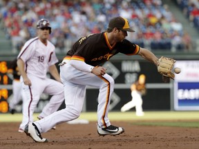 San Diego Padres third baseman Cory Spangenberg, right, fields a ground-out by Philadelphia Phillies' Andres Blanco as Tommy Joseph, left, looks on during the second inning of a baseball game, Friday, July 7, 2017, in Philadelphia. (AP Photo/Matt Slocum)