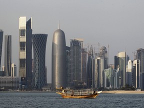 FILE - In this Thursday Jan. 6, 2011 file photo, a traditional dhow floats in the Corniche Bay of Doha, Qatar, with tall buildings of the financial district in the background. Qatar likely faces a deadline this weekend to comply with a list of demands issued to it by Arab nations that have cut diplomatic ties to the energy-rich country, though its leaders already have dismissed the ultimatum. (AP Photo/Saurabh Das, File)