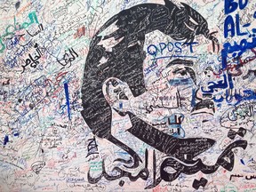 A black-and-white depiction of Qatar's emir, Sheikh Tamim bin Hamad Al Thani, attracts signatures and comments of support from residents amid a diplomatic crisis between Qatar and neighboring Arab countries in Doha, Qatar, on Monday, July 3, 2017. A group of Arab nations has extended a deadline for Qatar to respond to their list of demands in a diplomatic crisis roiling the Gulf by 48 hours, saying Kuwait's emir requested the delay as part of his efforts to mediate the dispute. (AP Photo/Maggie Hyde)