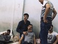 A man holds another migrant in a detention centre in Libya.