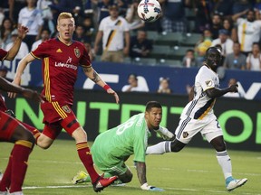 Real Salt Lake defender Justen Glad, from left, and LA Galaxy goalkeeper Nick Rimando (18) and midfielder Emmanuel Boateng battle at the goal in the first half of an MLS soccer match in Carson, Calif., Tuesday, July 4, 2017. (AP Photo/Reed Saxon)