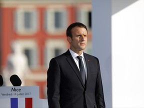French President Emmanuel Macron stands at attention during a ceremony in Nice, southern France, Friday, July 14, 2017. Commemorations followed Bastille Day celebrations for Macron, heading to the Riviera city of Nice for a solemn remembrance of the 86 lives lost one year ago when a 19-ton truck throttled through revelers feting France's national day in a terror attack that jolted the nation and stunned the world. (AP Photo/Laurent Cipriani)