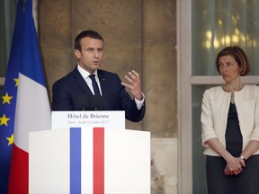 French President Emmanuel Macron flanked by French Defense Minister Florence Parly delivers a speech during a reception in honor of the French Army forces at the Defense Ministry in Paris, on the eve of the Bastille Day commemorations, Thursday, July 13, 2017.(AP Photo / Matthieu Alexandre, Pool)