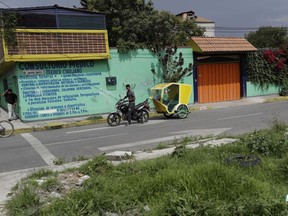 A motorcycle taxi driver pauses to look at marines blocking the area where a suspected drug gang leader and seven others were killed in a shootout in the Tlahuac district of Mexico City,  Thursday July 20, 2017. Mexico City residents were stunned by the sight of drug-war-style violence, including burnt-out vehicles and road blockades by gang-sympathizing motorcycle taxi drivers, in the nation's capital, sights that had previously been seen only in violence-wracked cities like Reynosa and Nuevo Laredo. (AP Photo/Rebecca Blackwell)