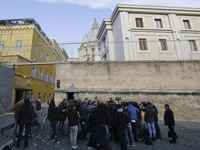 FILE - In this Tuesday, Nov. 24, 2015 file photo, Italian journalists Gianluigi Nuzzi and Emiliano Fittipaldi talk to reporters outside the Vatican City from the Perugino gate. Other than St. Peter's Basilica, there's hardly better real estate in this tiny city state than the sprawling penthouse apartment in the Vatican gardens, where the rooftop terrace has in-your-face views of the dome itself and overlooks the Vatican hotel that Pope Francis calls home. (AP Photo/Gregorio Borgia, File)