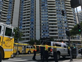 Law enforcement officers stand at the scene of a multi-alarm fire at a high-rise apartment building in Honolulu, Friday, July 14, 2017. Dozens of firefighters are battling the fire at Marco Polo apartments that Honolulu Fire Department spokesman Capt. David Jenkins said started on the 26th floor and has spread to other units. (AP Photo/Audrey McAvoy)